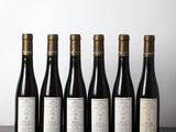 six bouteilles de vin alignées sur une table en bois