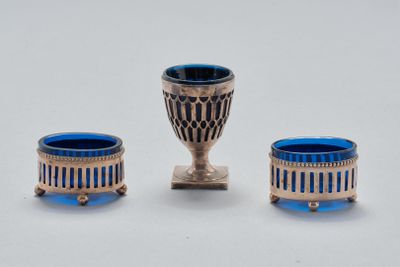 trois objets en verre argenté et bleu posés sur une table