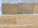 several pieces of old paper with writing on them sitting on a table