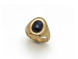 gros plan d'une bague en or avec une pierre noire