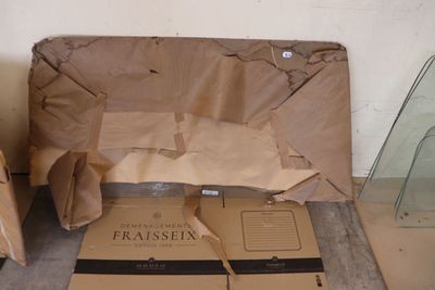 une boîte en carton posée par terre à côté d'une vitrine