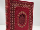 a red book with gold trimming on the cover
