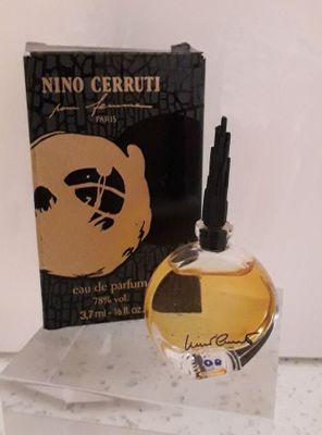 un flacon de parfum posé sur une table à côté d'une boîte
