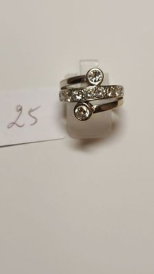 a silver ring with a diamond on it next to a piece of paper with a price tag