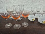 many glasses and cups sitting on a wooden table