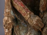 statue of a man sitting on a chair holding a wooden stick