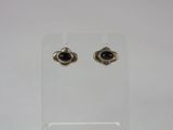 a pair of black stone earrings on a clear stand