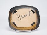an old photo of a brown and black plate with writing on it