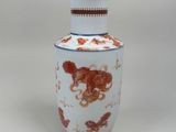 un vase blanc orné d'un motif rouge et blanc