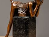 statue représentant une femme allongée sur un bloc de marbre