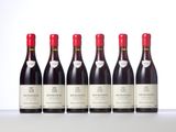 six bottles of red wine lined up in a row