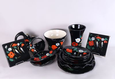 de nombreuses pièces de vaisselle noire et rouge disposées sur une table
