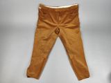 un gros plan sur un pantalon marron posé sur une surface blanche
