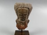 a close up of a statue of a head on a wooden stand