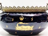 un grand vase bleu surmonté d'une couronne dorée
