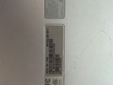 a close up of a silver laptop with a barcode on it