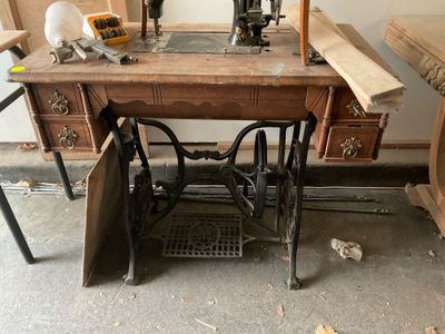 une machine à coudre posée sur une table en bois