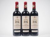 trois bouteilles de vin rouge posées l'une à côté de l'autre sur une surface blanche