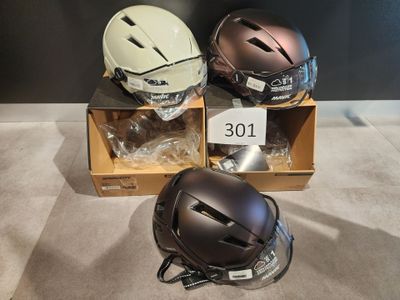 three helmets sitting on top of a cardboard box on top of a floor