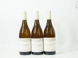 trois bouteilles de vin posées les unes à côté des autres sur une surface blanche