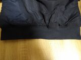 the back of a black jacket on a wooden floor