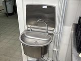 un lavabo et une poubelle dans des toilettes publiques