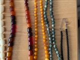 several necklaces and bracelets are displayed on a wooden tray