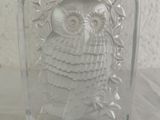 a glass block with an owl on it on a table