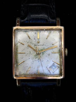 une photo d'une montre en or avec un bracelet en cuir bleu
