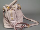 a white purse with a red handle on a gray surface