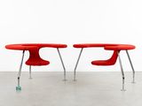 two red chairs sitting next to each other in a room