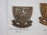 two metal badges with a picture of a ship and a ship