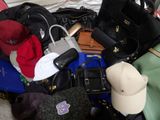 a pile of purses and hats sitting on a bed