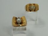 pair of gold and pearl earrings on clear acrylic stand