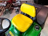 a green and yellow lawn mower sitting in a garage