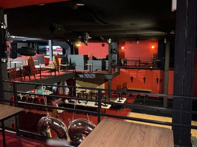 tables and chairs in a room with red walls and a black ceiling