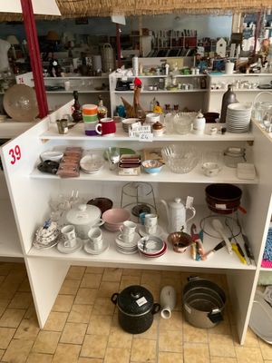 une cuisine où il y a beaucoup de vaisselle et de plats posés sur le plan de travail