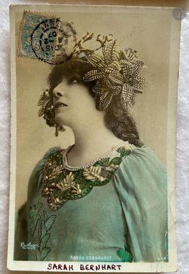 une vieille photo d'une femme en robe verte, avec une fleur dans les cheveux
