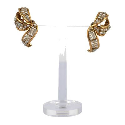 a close up of a pair of earrings on a stand