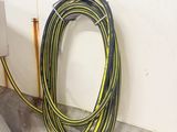 a yellow and black hose next to a white wall