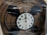 a clock that is wrapped in plastic on a table