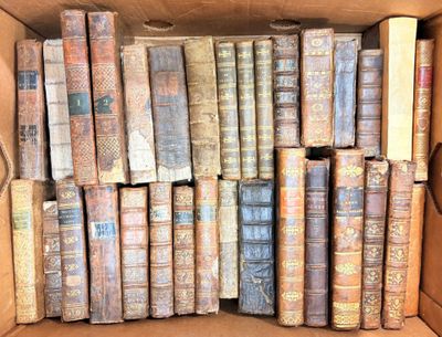 une boîte pleine de vieux livres posée sur le sol
