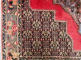 an oriental rug with a red border and fringes on the bottom