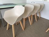four white chairs sit in front of a table with a book on top of it