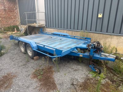 une remorque bleue garée devant un immeuble