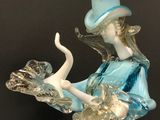 an image of a glass figurine of a woman with a hat on her head