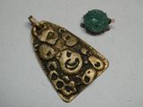 deux pièces d'or et un pendentif en jade vert sur un fond blanc