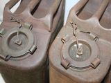 three old gas canisters sitting on a white surface