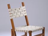 La chaise est en bois et possède une assise tressée.