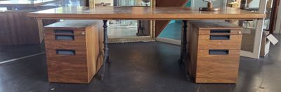 un bureau à deux tiroirs, sur lequel est posé un vase